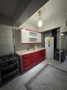 a kitchen with red cabinets and a stove and refrigerator at Tekinler Deluxe Suite in Diyarbakır
