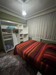 a bedroom with a bed with a striped blanket at Tekinler Deluxe Suite in Diyarbakır