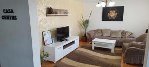 a living room with a television and a couch at "Apartament"-Casa Genius in Ploieşti