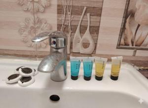 a sink with a faucet and four cups on it at شوران الأولى in Al Madinah