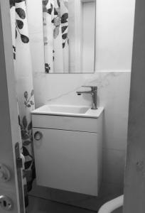 a white bathroom with a sink and a mirror at R suite delux in Netanya