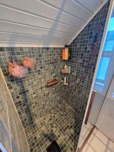 y baño con ducha y pared de azulejos. en Room in Trondheim, Heimdal, Lundåsen - Bus to town every 5 minutes, en Trondheim