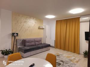 een woonkamer met een bank en een tafel bij Apartament Genius 2 in Ploieşti +10 foto's