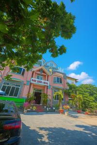a pink building with a car parked in front of it at Phát Thịnh Hotel in Ho Chi Minh City