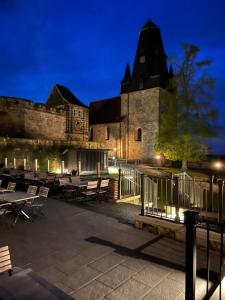 un edificio con tavoli e sedie di fronte ad esso di notte di "An der alten Mühle 2" - Fewo 80qm, zentral gelegen, zwei Schlafzimmer, Südterrasse und Wallbox a Bad Bentheim