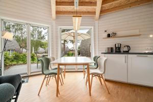 a kitchen and dining room with a table and chairs at Nordkugel - Rundes Wohnglück am Tollensesee in Wustrow +15 photos