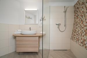 a bathroom with a sink and a shower at Nordkugel - Rundes Wohnglück am Tollensesee in Wustrow