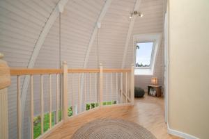a room with a staircase in a house at Nordkugel - Rundes Wohnglück am Tollensesee in Wustrow