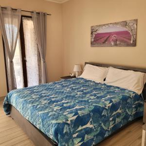 Un dormitorio con una cama con un edredón azul. en Villa Dall'Angelo Suite Mountain Lake Endine Hospitality, en Endine Gaiano