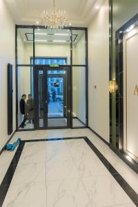 een liftlobby met een glazen deur waar mensen in lopen bij ЖК Атамура in Promyshlennyy