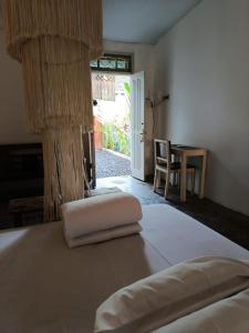 een slaapkamer met een bed met een tafel en een stoel bij Gusti Ayu Private Bali House - 2 Bedrooms near Kerobokan in Kerobokan