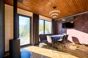 a dining room with a table and a large window at Blog House Resort in Yaremche