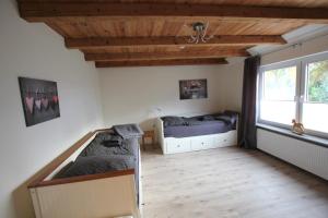 a bedroom with a bed and a bed and a window at Ferienhaus Weideblick in Hymendorf