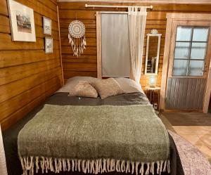 une chambre avec un lit dans une pièce aux murs en bois dans l'établissement Aurora Lodge, à Rovaniemi