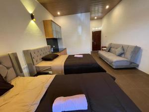 ein Hotelzimmer mit zwei Betten und einer Couch in der Unterkunft Hotel Florida Mandalika Lombok in Kuta Lombok
