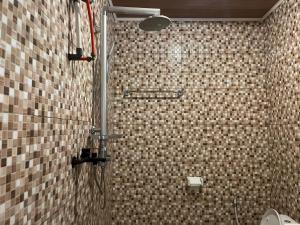 龙目岛库塔Sakila Guest House的一间带淋浴的浴室和瓷砖墙 更多33张照片