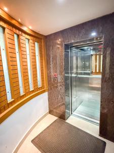 una ducha con puerta de cristal en un baño en Sathya Inn Guruvayur, en Trichūr