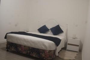 una camera da letto con un letto con cuscini blu di Casa da Quinta a Estreito da Calheta