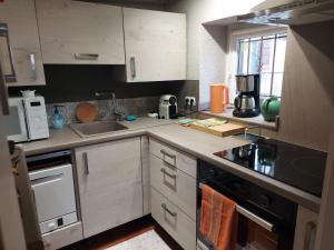 a kitchen with white cabinets and a stove top oven at La Maison Kouglof in Nordheim