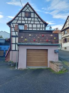 a building with a garage door in front of it at La Maison Kouglof in Nordheim