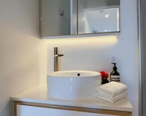 une salle de bain avec un lavabo, un miroir et des serviettes dans l'établissement Arnold Box Hill - Modern 2bed Apartment, à Box Hill 5 autres photos