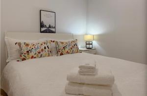 - un lit blanc avec un tas de serviettes dans l'établissement Arnold Box Hill - Modern 2bed Apartment, à Box Hill