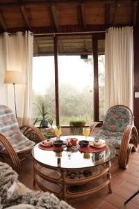 a living room with a table and chairs and a large window at Cabaña en Santa Elena con vista a Medellín in Santa Elena