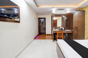 a bedroom with a bed and a kitchen with a table at Collection O by OYO Flavour in Āsansol +27 photos