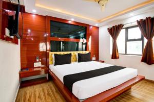 a bedroom with a bed and a television in it at Collection O by OYO Flavour in Āsansol