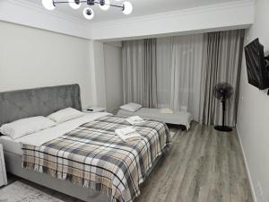 ein Schlafzimmer mit einem Bett mit einer karierten Decke in der Unterkunft Уютный Дом in Chişinău + 29 Fotos