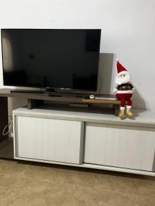 a santa claus doll sitting on top of a tv stand at Duplex 1 Villa Ramallo in Estación Ramallo