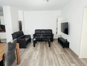 a living room with black leather furniture and a flat screen tv at Miracle 3 Betts Apart mit Parkplatz in Altomünster