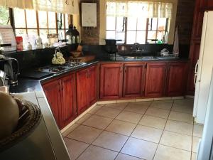 a kitchen with wooden cabinets and a counter top at Big Tuskers Bush Camp in Marloth Park