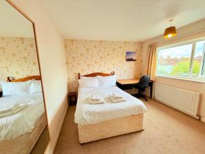 Una habitación de hotel con dos camas y un espejo. en A Perfect Work Base & Family House in Fishpoads, en Bristol