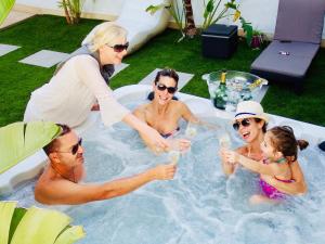a group of people drinking champagne in a jacuzzi at Villa Cleo, vistas de ensueño in San Miguel de Abona