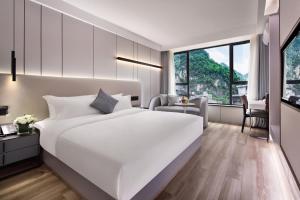 een slaapkamer met een groot wit bed en een bureau bij 妙酒店阳朔西街漓江店 in Yangshuo