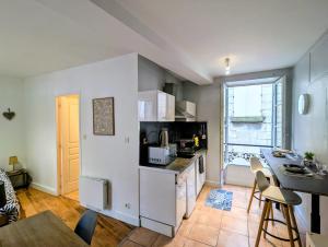 a kitchen with white appliances and a table with chairs at Charmant studio rénové hyper centre in Périgueux