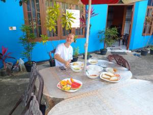 Un hombre sentado en una mesa con comida. en Jaga's Hill homestay, en Kandy