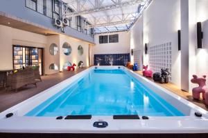 een groot zwembad met blauw water in een gebouw bij 妙酒店阳朔西街漓江店 in Yangshuo