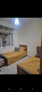 una camera da letto con due letti e una finestra di Gravereau a Oujda