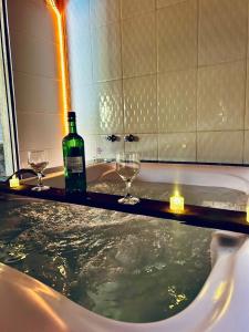 eine Flasche Wein und zwei Gläser in der Badewanne in der Unterkunft Quiosque Família Chalé Beija-Flor in Joanópolis