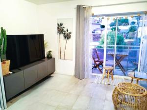 una sala de estar con un televisor de pantalla plana sobre un mueble en Escapade à Bandol balcon verdoyant et plage à deux pas, en Bandol