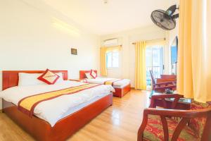 a hotel room with a bed and a desk and chairs at Hoàng Hà Hotel Tam Đảo in Tam Ðảo