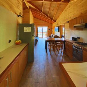 a kitchen with a green refrigerator and a table at Casa Pullinque en Panguipulli in Panguipulli