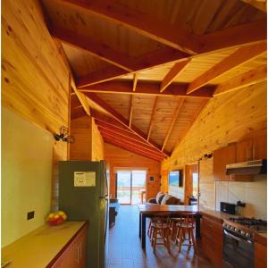 a kitchen with a green refrigerator and a table at Casa Pullinque en Panguipulli in Panguipulli