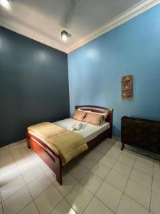 a bedroom with a bed in a blue wall at Kota Puteri Vibe Kampung Homestay in Batu Arang