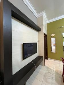 a living room with a flat screen tv on a wall at Kota Puteri Vibe Kampung Homestay in Batu Arang