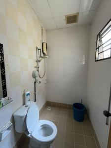 a bathroom with a toilet and a phone on the wall at Kota Puteri Vibe Kampung Homestay in Batu Arang