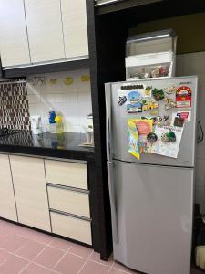 a kitchen with a white refrigerator with many magnets at Kota Puteri Vibe Kampung Homestay in Batu Arang +3 photos