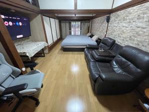 a living room with a couch and a bed at Sakurahome&El Flamenquito in Muroto